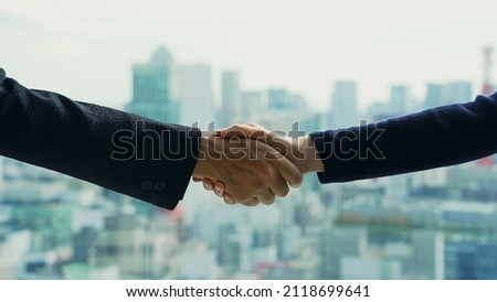 Couple of people shaking hands in front of the city. Royalty-Free Stock Photo #2118699641