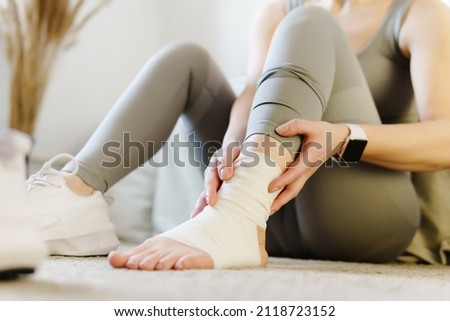 Sport injury leg pain - woman hurting holding painful sprained ankle muscle. Female athlete with joint or muscle soreness and problem feeling ache.