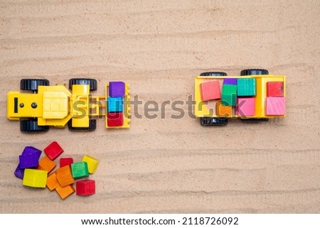 Toy tractors work in the sand Wooden toy car in cartoon style on yellow background. Colorful and Transportation background, eco kid toys Montessori . 