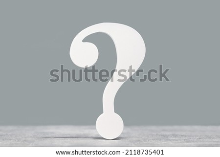 White question mark symbol on a gray desk background