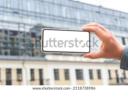 Close-up, Mockup of a smartphone in the hands of a man. Against the backdrop of a glass business center