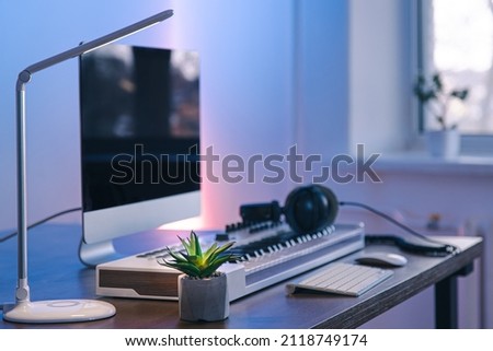 Computer, midi keyboard and headphones on the table, music creation concept.