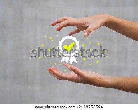 a young woman's hand showing a certification mark Quality assurance, business standard assurance with ISO system.