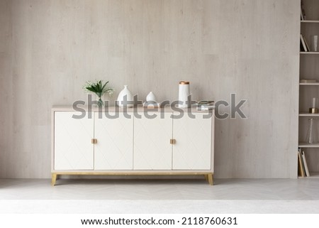White modern dresser minimalistic furniture in empty room on grey wall background, small cupboard with decor, vases and lily of the valley flowers bouquet, cozy apartment house interior concept Royalty-Free Stock Photo #2118760631
