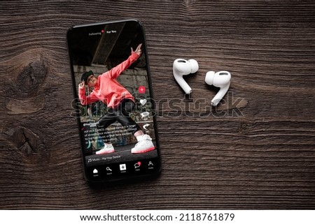 Sample social media app interface on mobile phone, concept of modern networking and sharing of video content Royalty-Free Stock Photo #2118761879