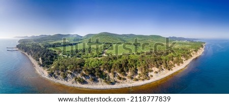 Panorama of the Black Sea coast from a bird's-eye view. The northern coast between the village of Beregovoe and Krinitsa. A grove of Pitsunda pine, a pebble beach and mountains on the horizon