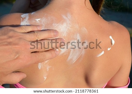 hands are rubbing suntan cream on the back. Close-up of applying sunscreen. Summer skin and body care. Man using foam to protect the skin. sun protection concept