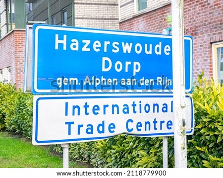 Place name sign of Hazerswoude-dorp, municipality of Alphen aan den Rijn in The Netherlands. Sign below says that International Trade Center (for tree nurseries) is located there.