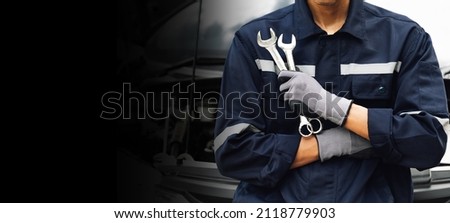 Hand of car mechanic with wrench. Auto repair garage. mechanic works on the engine of the car in the garage. Repair service. Concept of car inspection service and car repair service. Royalty-Free Stock Photo #2118779903