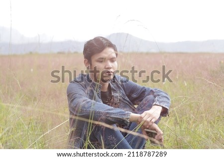 Asian Boy with Sad Expression on Grass