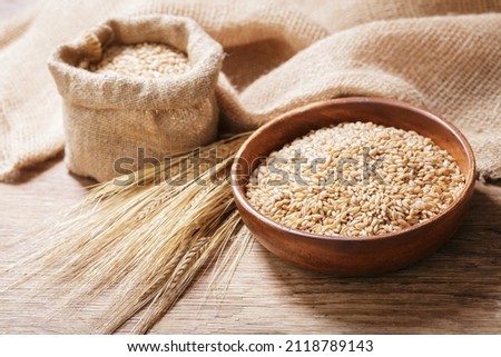 bowl of barley grains on a wooden table Royalty-Free Stock Photo #2118789143