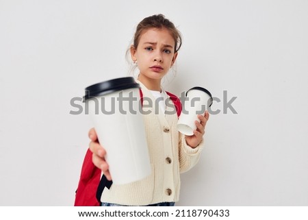 schoolgirl with a red backpack a glass with a drink in her hands