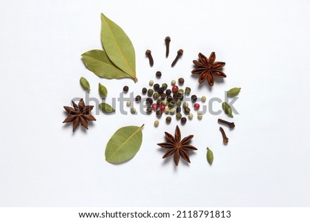 Assorted colorful spices peppercorns, bay leaf, cardamom, anise, clove on white background. Royalty-Free Stock Photo #2118791813