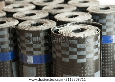 rolls of bituminous waterproofing standing in a warehouse Royalty-Free Stock Photo #2118809711