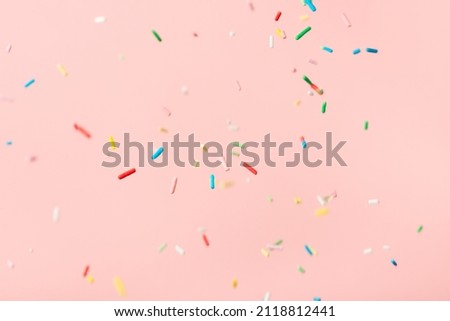 flying colorful sprinkles over pink background Royalty-Free Stock Photo #2118812441