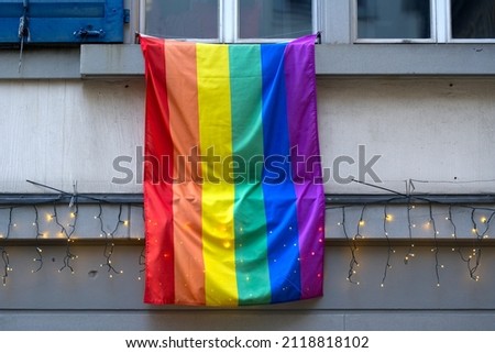 Lbgt rainbow flag hanging from window ledge at the old town of Zürich on a sunny winter day with Christmas lights. Photo taken February 5th, 2022, Zurich, Switzerland.
