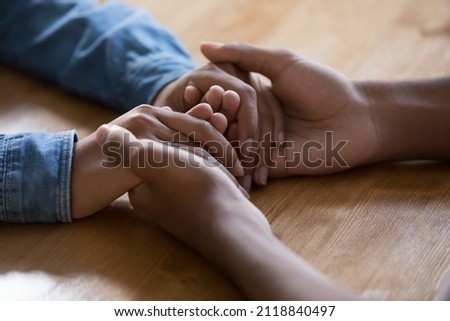 African man touching hands of young girlfriend over table surface, making support, care gesture, giving compassion, empathy, forgiveness. Close up, cropped shot Royalty-Free Stock Photo #2118840497