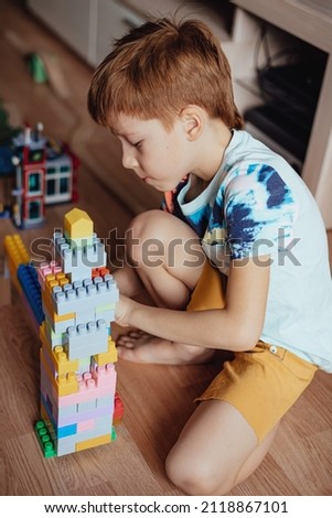 Child preschooler playing kosturctor at home, vertical photo.