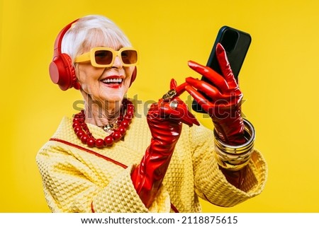 Happy and funny cool old lady with fashionable clothes portrait on colored background - Youthful grandmother with extravagant style, concepts about lifestyle, seniority and elderly people Royalty-Free Stock Photo #2118875615