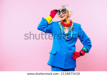 Happy and funny cool old lady with fashionable clothes portrait on colored background - Youthful grandmother with extravagant style, concepts about lifestyle, seniority and elderly people Royalty-Free Stock Photo #2118875618