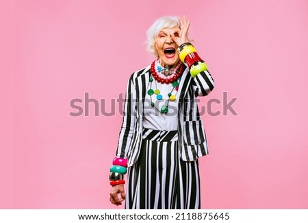 Happy and funny cool old lady with fashionable clothes portrait on colored background - Youthful grandmother with extravagant style, concepts about lifestyle, seniority and elderly people Royalty-Free Stock Photo #2118875645