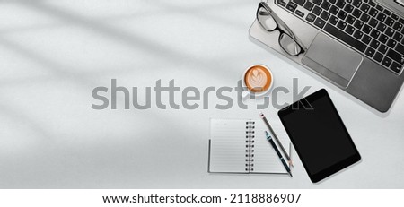 White office table workplace with laptop, tablet, notebook, a cup of coffee art with copy space design for web banner, brochure, background. Flatlay, Top view. Royalty-Free Stock Photo #2118886907