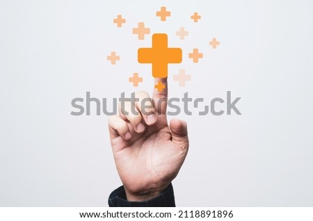 Businessman touching virtual orange plus sign for positive thinking mindset or healthcare insurance symbol concept. Royalty-Free Stock Photo #2118891896