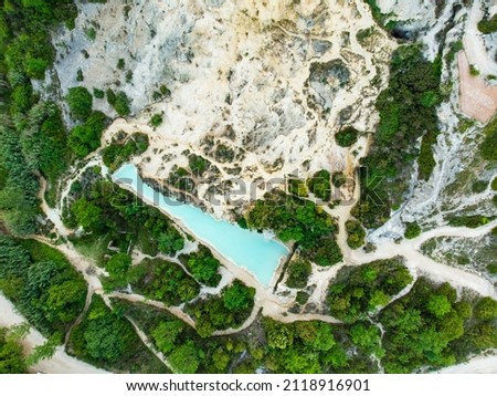 Aerial view of natural swimming pool in Bagno Vignoni, with thermal spring water and waterfall. Geothermal pools and hot springs in Tuscany, Italy. Royalty-Free Stock Photo #2118916901