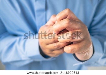 Fingers pain in office syndrome concept. Salaryman wears a blue shirt. Medium close up shot.