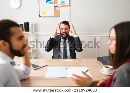 Stop fighting. Angry lawyer screaming to a couple getting divorce in his office  Royalty-Free Stock Photo #2118924083