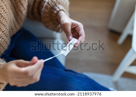 Young African woman holding self testing self-administrated swab and medical tube for Coronavirus covid-19, before being self tested at home