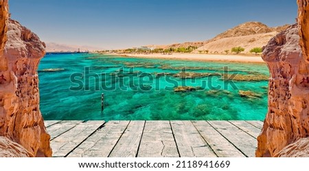 Coral reefs of the Red Sea and foreground of rocks and wooden footpath as a copy space for web banner Royalty-Free Stock Photo #2118941669
