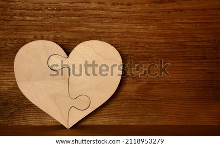 complete wooden heart shape jigsaw puzzle on wood board  background . 2 two pieces. two person in relationship.  Royalty-Free Stock Photo #2118953279