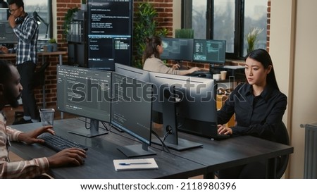 Two focused coders facing each other writing code in software development office while team of coders are developing artificial intelligence. Team of programmers innovating algorithm code. Royalty-Free Stock Photo #2118980396