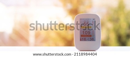 air quality meter on the windowsill shows poor quality at sunrise in the early morning. air quality tester for air quality for measuring humidity, temperature and air purity. poor monitor Royalty-Free Stock Photo #2118984404