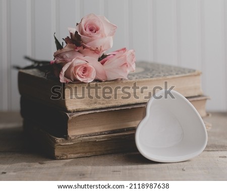 Rose and a book for a gift on a wooden rustic background with  space for text —