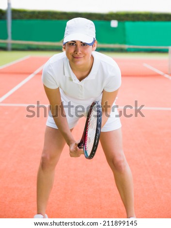 Pretty tennis player smiling at camera on a sunny day