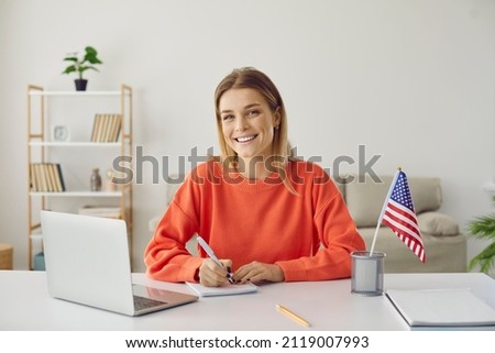 Student at desk studying free online American university academic course during global Covid 19 pandemic, writing essay, scholarship application, preparing for youth job, work travel, USA immigration Royalty-Free Stock Photo #2119007993