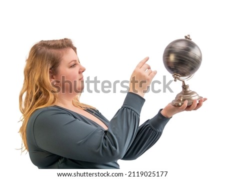 Woman holds a globe in her hands and spins it. Looking for a new destination. The woman in the photo is a plus size model