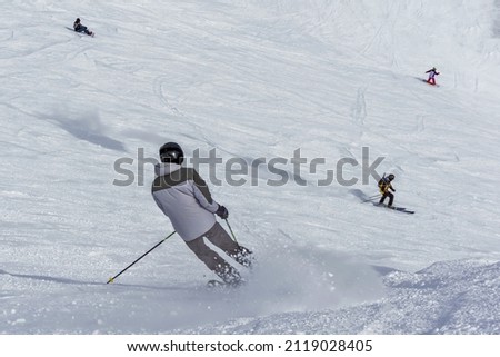 People are skiing on a snowy slope. 