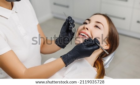 Banner for dental theme. Close-up of female smile with white teeth during medical examination. Concept of tooth whitening, treatment, veneers, professional clinic. Photo with free copy space. Royalty-Free Stock Photo #2119035728