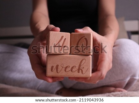 Pregnant woman holding cubes with 40 weeks gestation