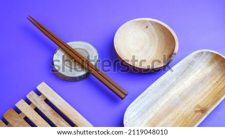 Wooden tableware that gives a classic and minimalist impression. Food and drink concept. Food Photography. Blue background. Wooden Bowl and chopsticks on the table.