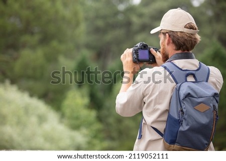 back view of man photographer taking photographs of nature