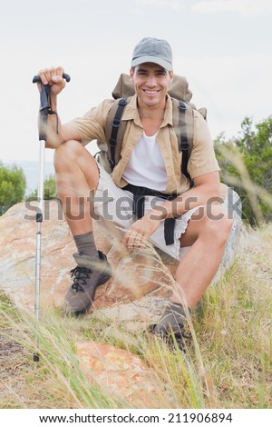 Portrait of a hiking man sitting on mountain terrain