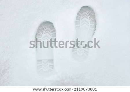 Footprints in fresh snow. Natural background with snow texture. Place for text, copyspace.
