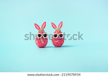 Colorful Easter egg with bunny ears and sunglasses on a blue background. Sale banner, mockup template. With copy space