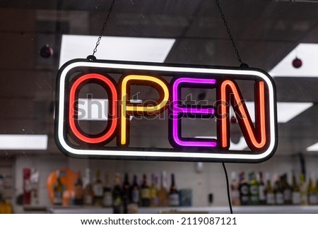 A neon open sign in a shop window.