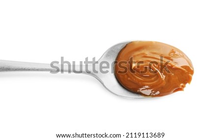 Spoon with tasty boiled condensed milk isolated on white, top view Royalty-Free Stock Photo #2119113689