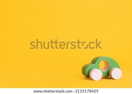Wooden toy car in cartoon style on yellow background. Colorful and Transportation background, eco kid toys Montessori . 